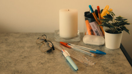 Pencil, Glasses, candle and other stationery on table