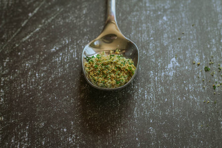 Spoonful of grated cannabis weed, on black wooden backgroundの写真素材