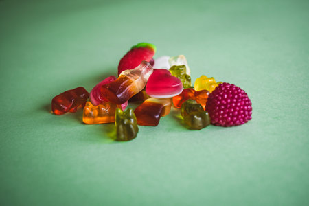 Colorful candies on green background. Top view. Toned.の写真素材