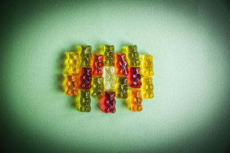 Colorful gummy bear candies on green background. Toned.の写真素材