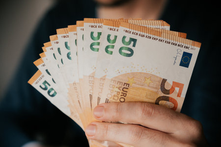 Close-up of a man holding euro banknotes in his handsの写真素材