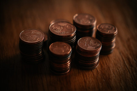 Stacks of coins on wooden table. Shallow depth of field