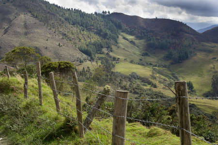 Barbed wire fence in the serria of ecuador with andes mountains in backgroundの写真素材