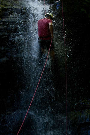ZAMORA REGION, YANTZAZA, ECUADOR-May 11:Rappel student climbs down waterfall  in Yantzaza, Ecuador on May 11, 2013. Rappelling is part of a tourism class.のeditorial素材