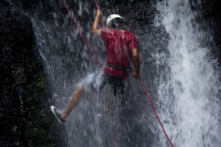 ZAMORA REGION, YANTZAZA, ECUADOR-May 11:Rappel student climbs down waterfall  in Yantzaza, Ecuador on May 11, 2013. Rappelling is part of a tourism class.のeditorial素材