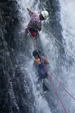 ZAMORA REGION, YANTZAZA, ECUADOR-May 19:Rappel student climbs down waterfall guided by instructors in Yantzaza, Ecuador on May 11, 2013. Rappelling is part of a tourism class.のeditorial素材