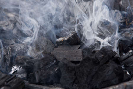 Close-up of smoke rising from Charcoal used in cooking grillの写真素材