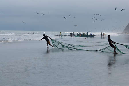 SAN CLEMENTE, MANABI, ECUADOR-Circa  August 2013:Fishermen pull in their nets  in San Clemente, Ecuador on Circa August 2013. Traditional Daily catches feed the village and provide incomeのeditorial素材