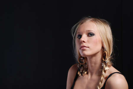 Portrait of a blonde girl with a braid on black backgroundの写真素材