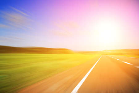 Blurred road and blurred sky with a shining sunの写真素材