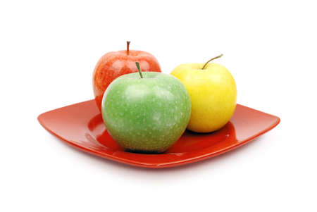 A close up of a  red plate with juicy green yellow and red appleの写真素材