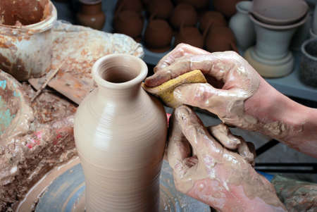 hands of a potter, creating an earthen jar on the circleの写真素材
