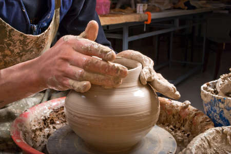 hands of a potter, creating an earthen jar on the circleの写真素材