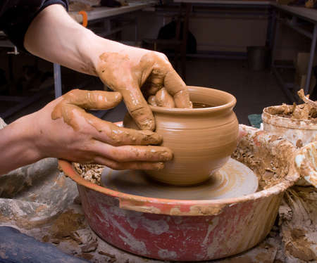 hands of a potter, creating an earthen jar on the circleの写真素材