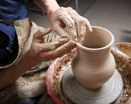 hands of a potter, creating an earthen jar on the circleの写真素材