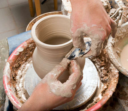 hands of a potter, creating an earthen jar on the circleの写真素材