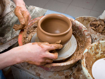 hands of a potter, creating an earthen jar on the circleのeditorial素材