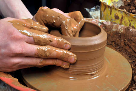 hands of a potter, creating an earthen jar on the circleの写真素材