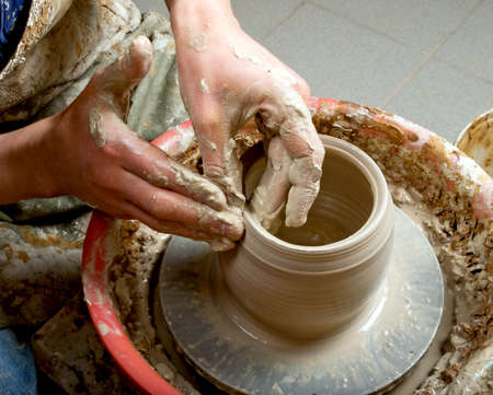 hands of a potter, creating an earthen jar on the circleの写真素材