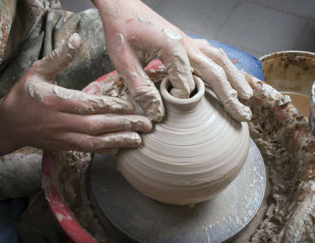 hands of a potter, creating an earthen jar on the circleの写真素材