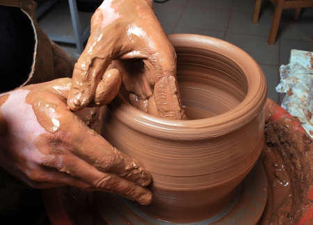 hands of a potter, creating an earthen jar on the circleの写真素材