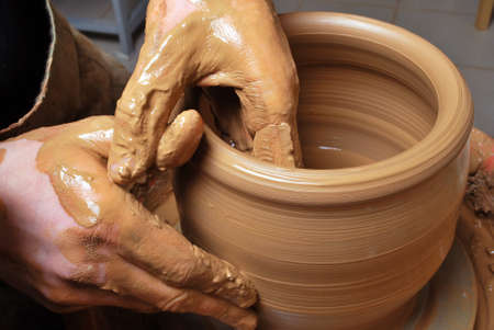 hands of a potter, creating an earthen jar on the circleの写真素材