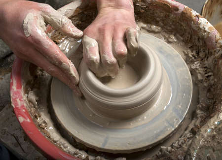 hands of a potter, creating an earthen jar on the circleの写真素材