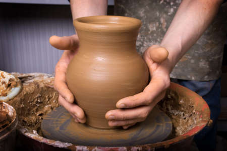 hands of a potter, creating an earthen jar on the circleの写真素材