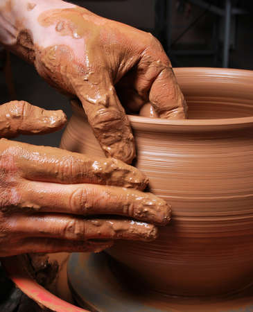 hands of a potter, creating an earthen jar on the circleの写真素材