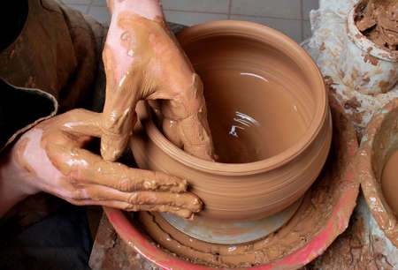 hands of a potter, creating an earthen jar on the circleの写真素材