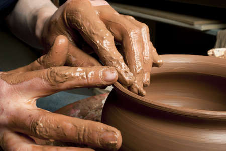 hands of a potter, creating an earthen jar on the circleの写真素材