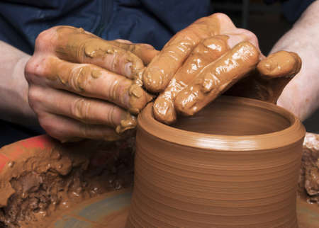 hands of a potter, creating an earthen jar on the circleの写真素材