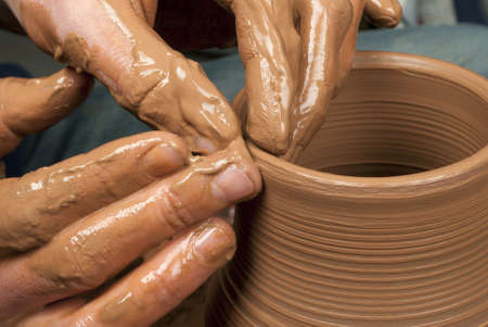 hands of a potter, creating an earthen jar on the circleの写真素材
