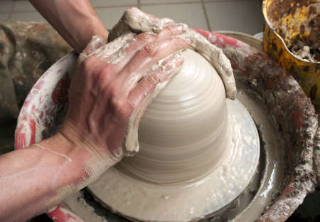hands of a potter, creating an earthen jar on the circleの写真素材