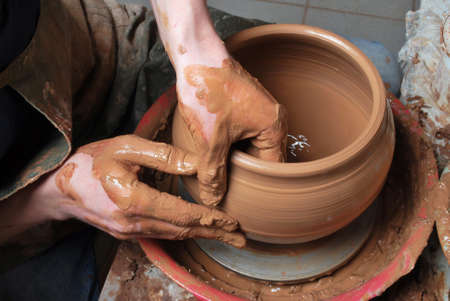 hands of a potter, creating an earthen jar on the circleの写真素材