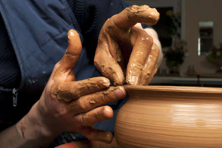 hands of a potter, creating an earthen jar on the circleの写真素材