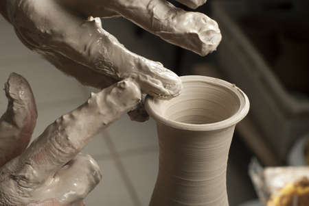 hands of a potter, creating an earthen jar on the circleの写真素材