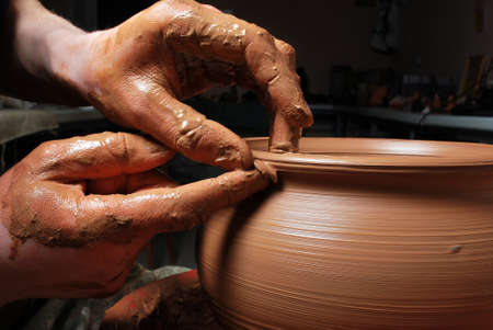 hands of a potter, creating an earthen jar on the circleの写真素材