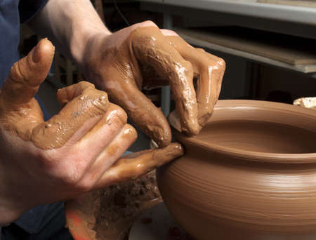 hands of a potter, creating an earthen jar on the circleの写真素材