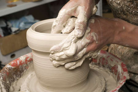 hands of a potter, creating an earthen jar on the circleの写真素材