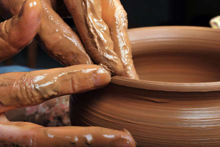 hands of a potter, creating an earthen jar on the circleの写真素材
