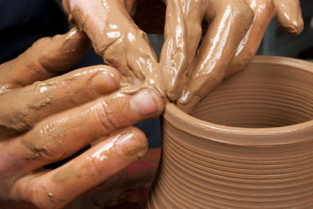 hands of a potter, creating an earthen jar on the circleの写真素材