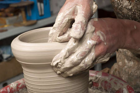 hands of a potter, creating an earthen jar on the circleの写真素材