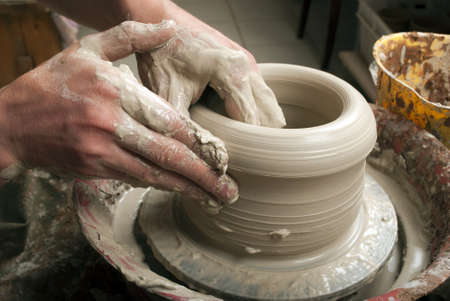 hands of a potter, creating an earthen jar on the circleの写真素材