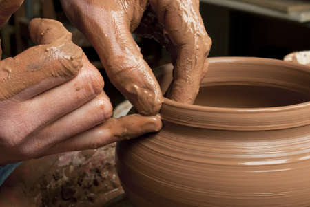 hands of a potter, creating an earthen jar on the circleの写真素材