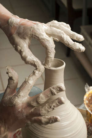 hands of a potter, creating an earthen jar on the circleの写真素材