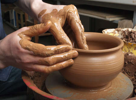 hands of a potter, creating an earthen jar on the circleの写真素材
