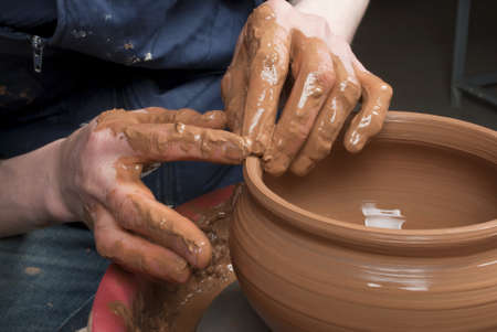 hands of a potter, creating an earthen jar on the circleの写真素材