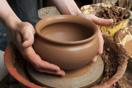 hands of a potter, creating an earthen jar on the circleの写真素材