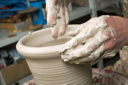 hands of a potter, creating an earthen jar on the circleの写真素材